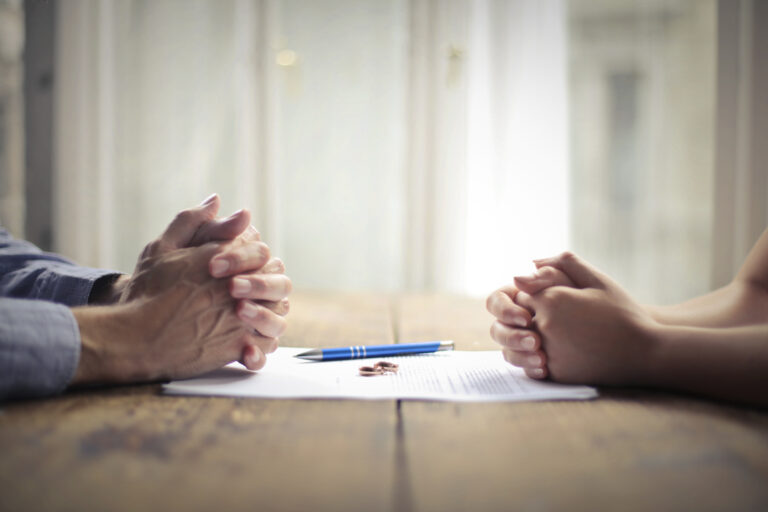 Two sets of hands over document at meeting