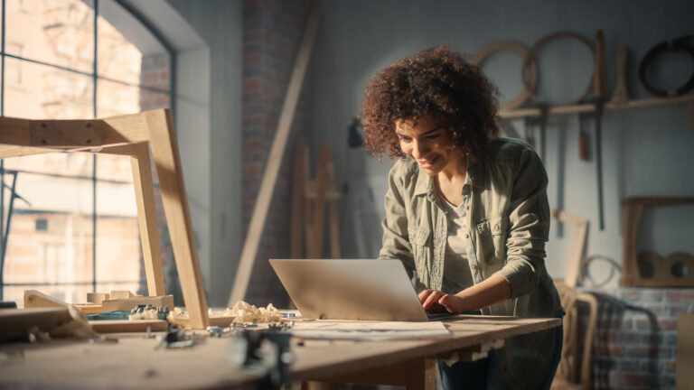 artist in studio sitting at laptop