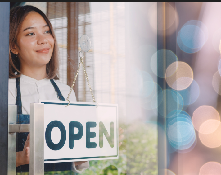 woman holding sign inside window 