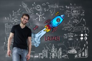 Portrait of cheerful man at chalkboard with sketch of space ship behind him