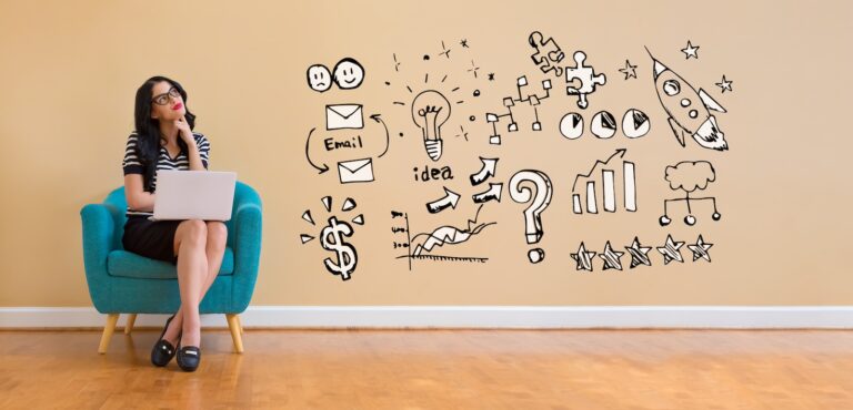 Woman using laptop envisioning business strategies that appear on the wall in cartoon form