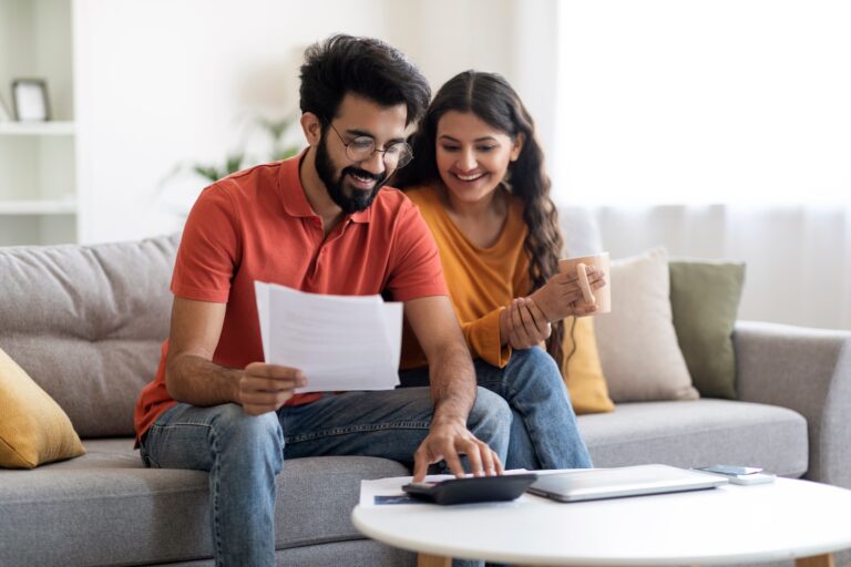 Couple sitting on couch looking at financial documents