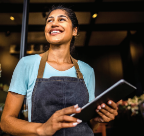 woman holding notebook outside of her business